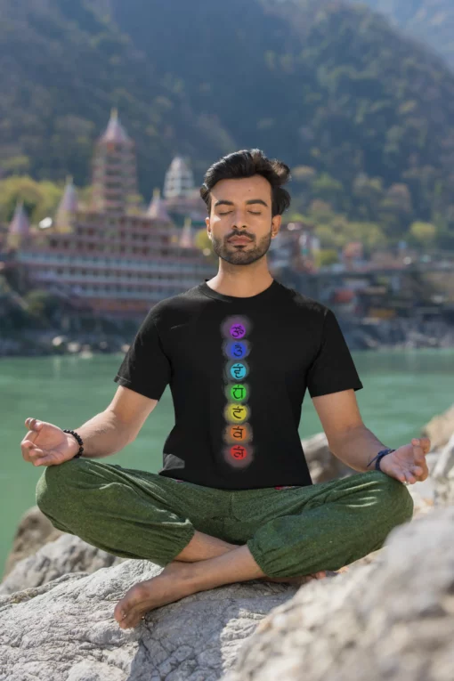 man wearing 7 chakra yoga black tshirt and meditating